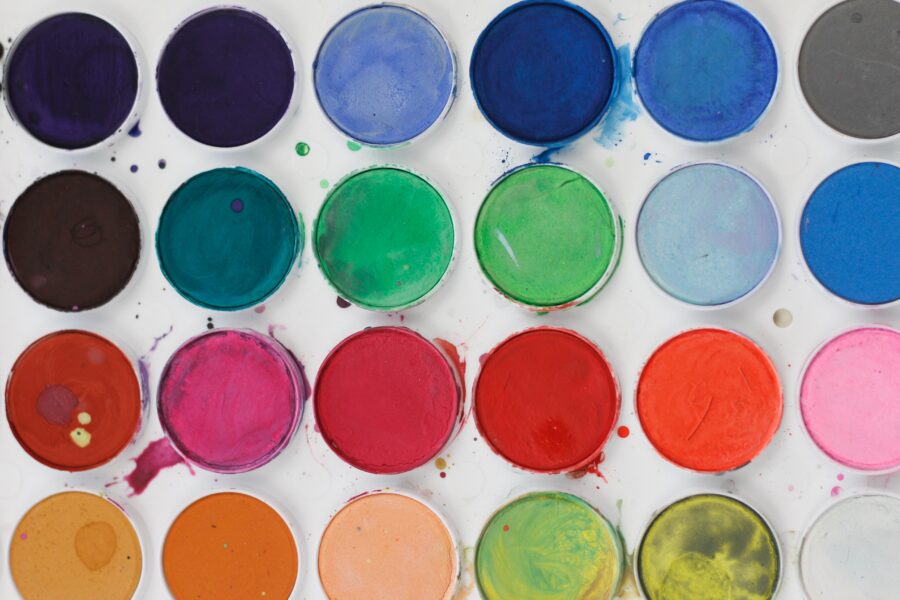 Different coloured small pots of watercolouring paint.