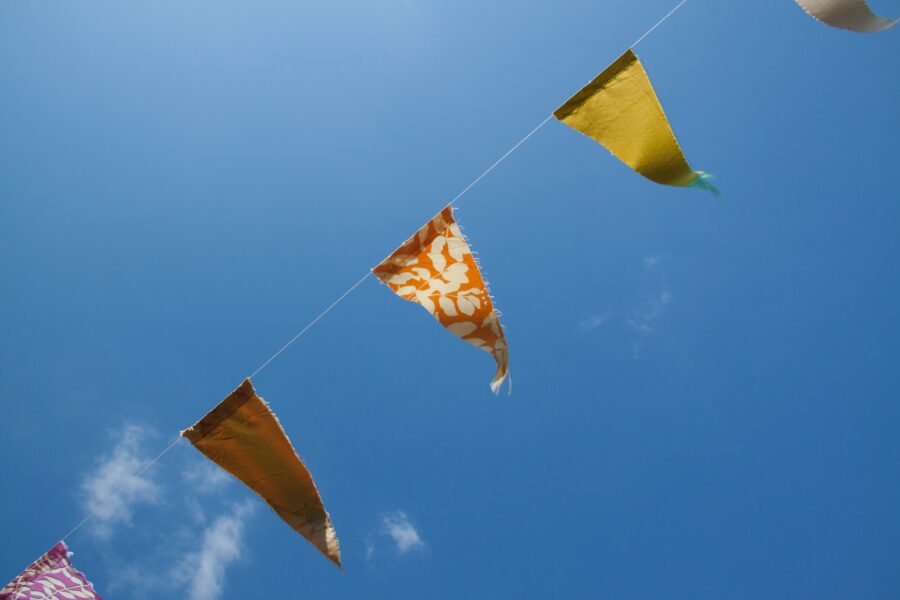A string of bunting against a bright blue sky.