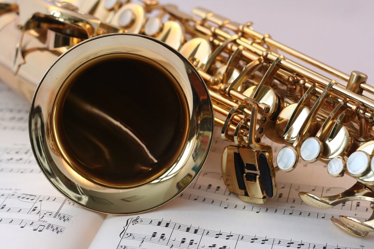 A close up of a saxophone placed on a sheet of music.