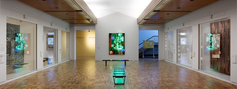 A photograph of the Exchanges exhibition installation space, showing a wide angle view of the gallery with its wooden floors and white walls - with illuminated inset display cabinets.
