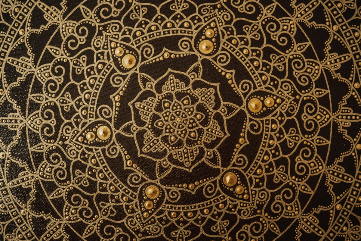 A gold and black, intricate mandala pattern.