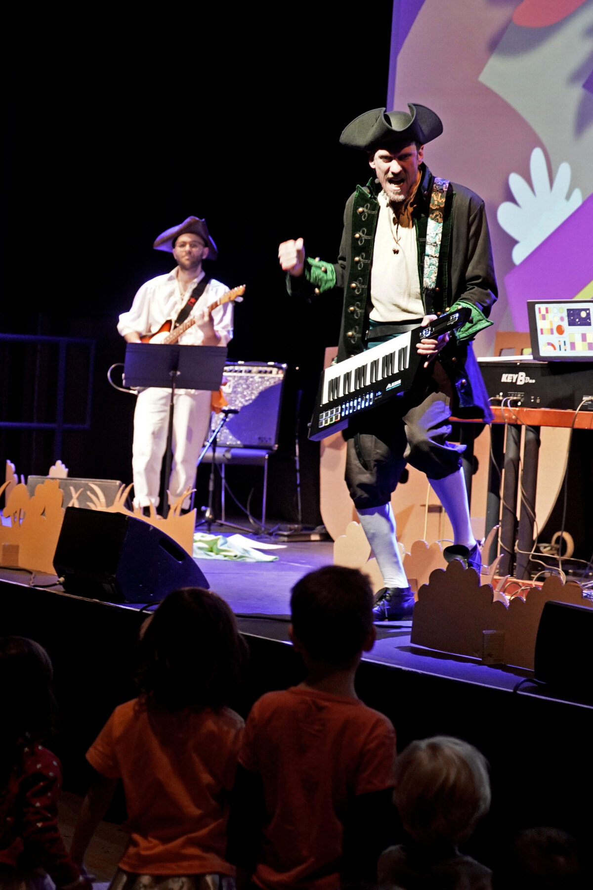 Two musicians dressed up as pirates performing on a stage.