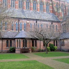 Gorton Monastery external building with a courtyard, paths and green lawn.