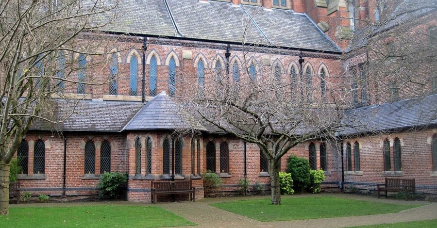 Gorton Monastery external building with a courtyard, paths and green lawn.