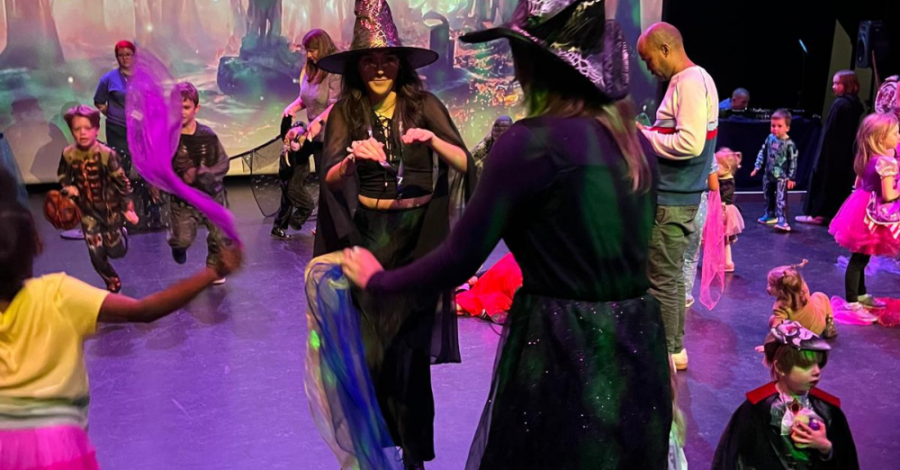 A group of young people in Halloween fancy dress playing party games.