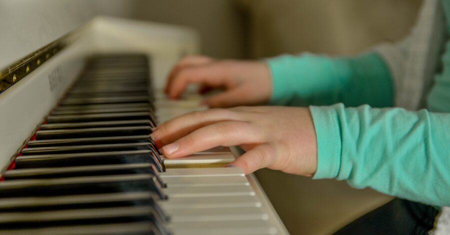 A pair of hands playing the keyboard on a piano.