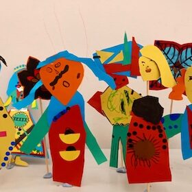 Paper models of people dressed in brightly coloured clothes