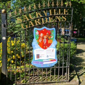 The park gates of Sackville Gardens with a Blue Peter poster displayed on them.