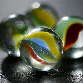 Four glass marbles on a surface.