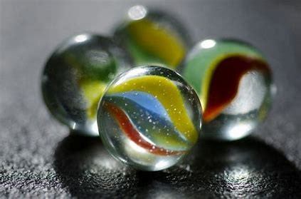 Four glass marbles on a surface.