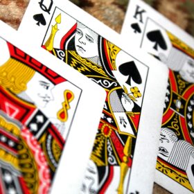 A King, Jack and Queen of Spades playing cards on a table.