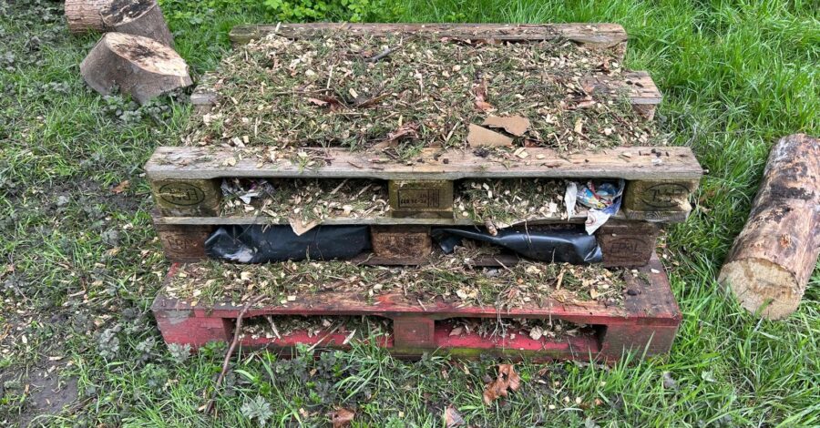 A bug hotel crafted from scrap wooden pallets.