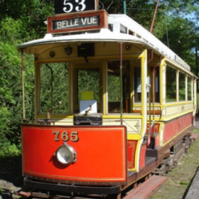 One of Heaton Parks heritage trams. It is painted red , white and yellow and has the number '53' and the words 'Belle Vue' on the front.