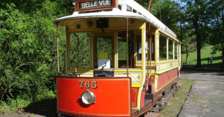 One of Heaton Parks heritage trams. It is painted red , white and yellow and has the number '53' and the words 'Belle Vue' on the front.