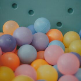 A number of small plastic balls in pastel colours like blue, pink, lilac, yellow and orange.