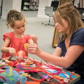 Woman making dream catchers with a young girl