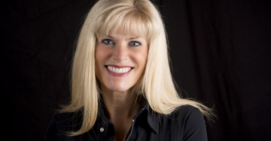 A picture of the head and shoulders of author Caroline England. She wears a black top, has light blonde hair and is smiling.