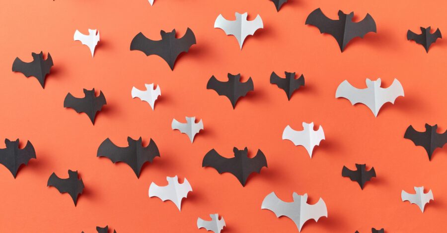 Black and white paper bats on an orange background.