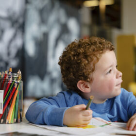 A young boy enjoying a colouring activity.