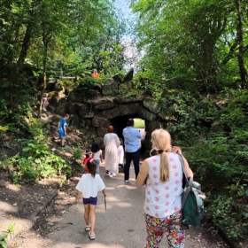 A group of people walk on a pathway in a park.