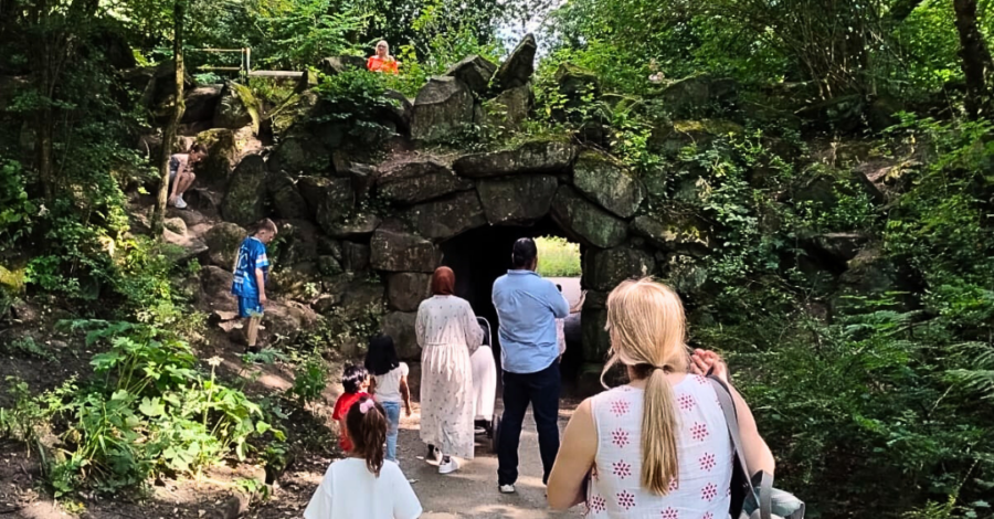 A group of people walk on a pathway in a park.