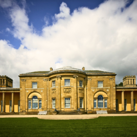 The front of Heaton Hall on a bright day. There is a big white cloud in the sky.