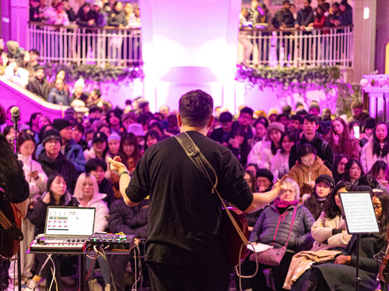 A musician performs to a packed Main Hall at Manchester Museum, during one of their Museum Lates.