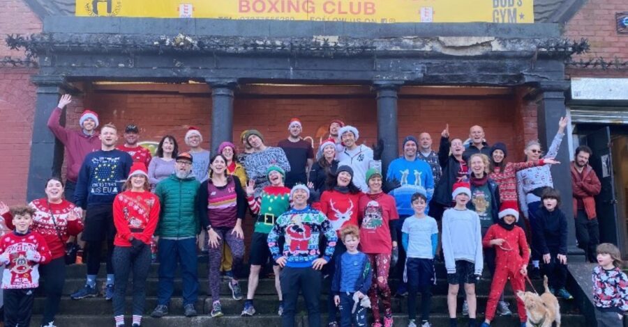 A crowd of people in christmas costumes stood outside Levenshulme Boxing Club before taking part on a Santa Run.