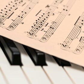 Some sheet music on top of a piano keyboard.