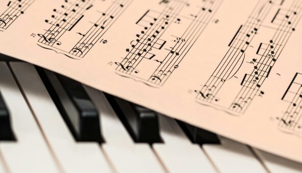 Some sheet music on top of a piano keyboard.