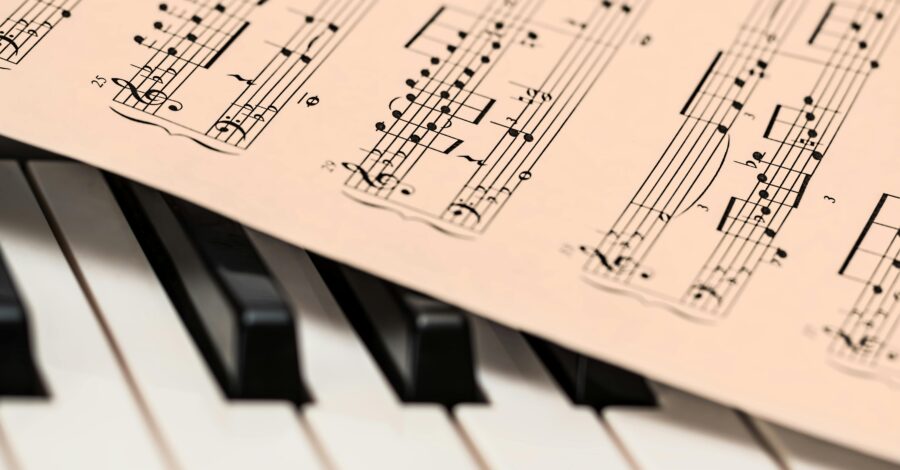 Some sheet music on top of a piano keyboard.