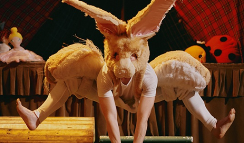 A dancer costumed as a rabbit leaps in the air