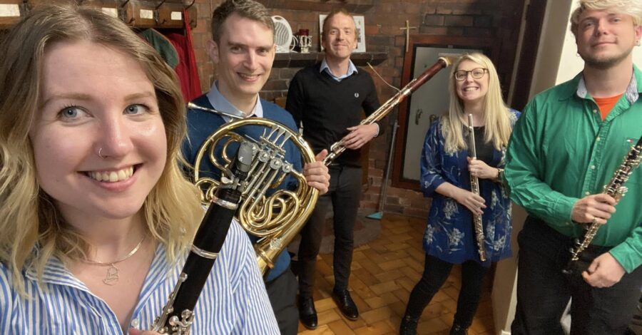 The Northerly Winds musical quintet holding their instruments and smiling.