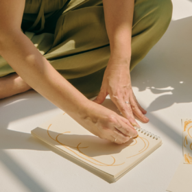 A woman sat doing therapeutic artwork in a journal.