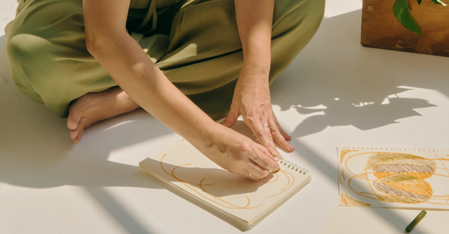 A woman sat doing therapeutic artwork in a journal.