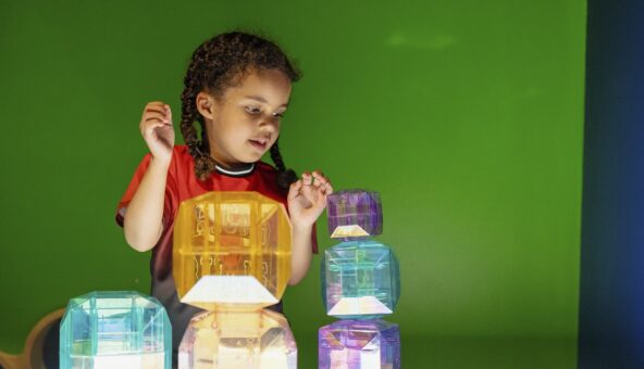 A young girl playing with brightly coloured blocks.