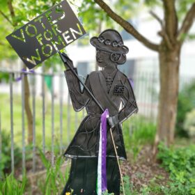Metal Suffragette sculpture holding a 'Votes for Women' sign.
