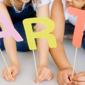 Children holding letters on sticks spelling out ART