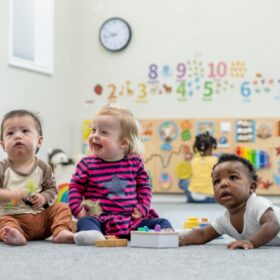 Three babies playing together in a Sure Start Centre.