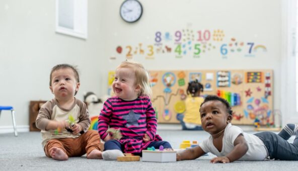 Three babies playing together in a Sure Start Centre.