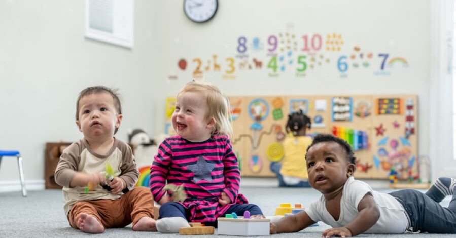 Three babies playing together in a Sure Start Centre.