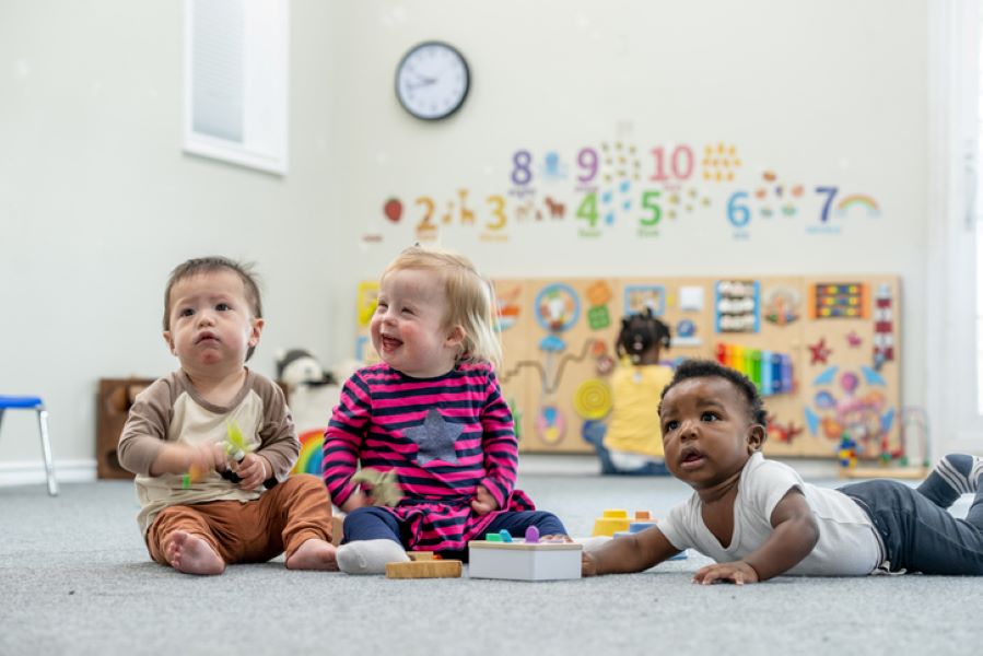 Three babies playing together in a Sure Start Centre.