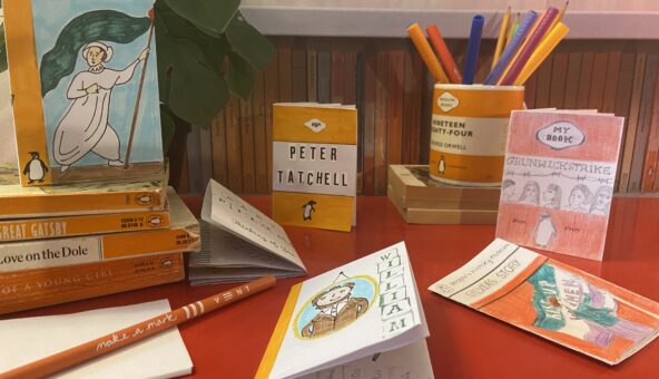 A display of mini paperback books and pencils.