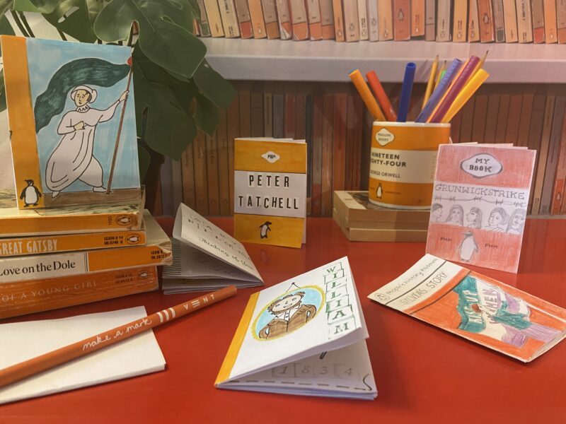 A display of mini paperback books and pencils.