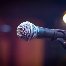 A silver and black microphone on a stand.
