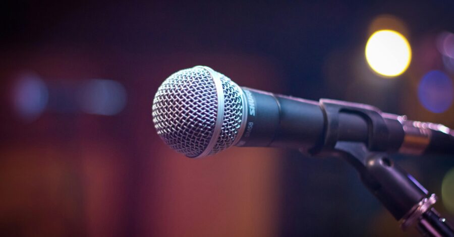 A silver and black microphone on a stand.