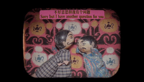 Two colorful hand puppets. One wears a plaid shirt, while the other is dressed in a vibrant, paisley-patterned outfit.