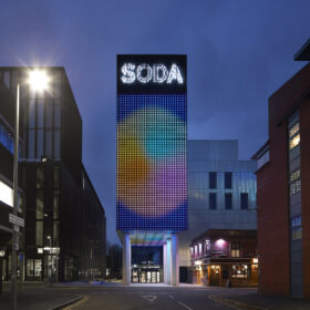 The School of Digital Arts Building, part of the Manchester metropolitan University, lit up at night.
