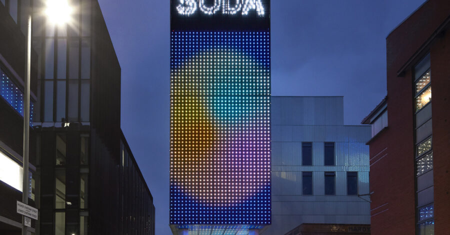 The School of Digital Arts Building, part of the Manchester metropolitan University, lit up at night.