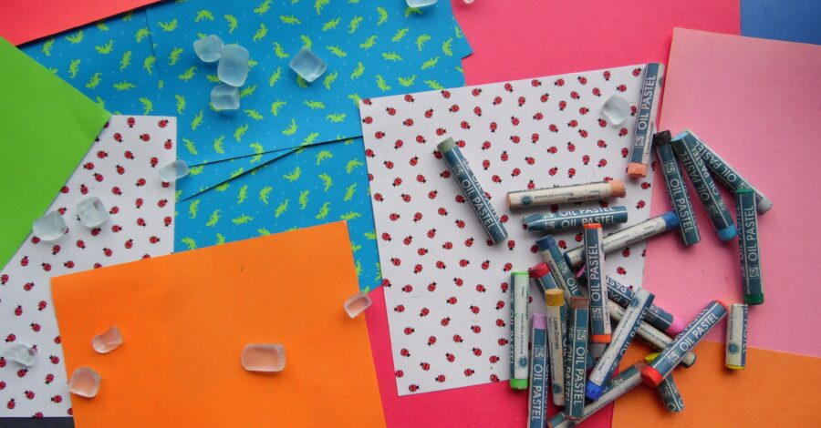 Some coloured paper and crafting supplies including crayons.